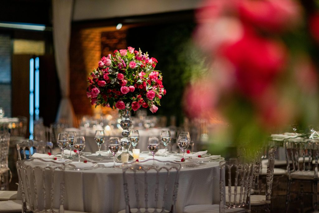 Stunning wedding venue showcasing a vibrant pink rose centerpiece on a beautifully set table.