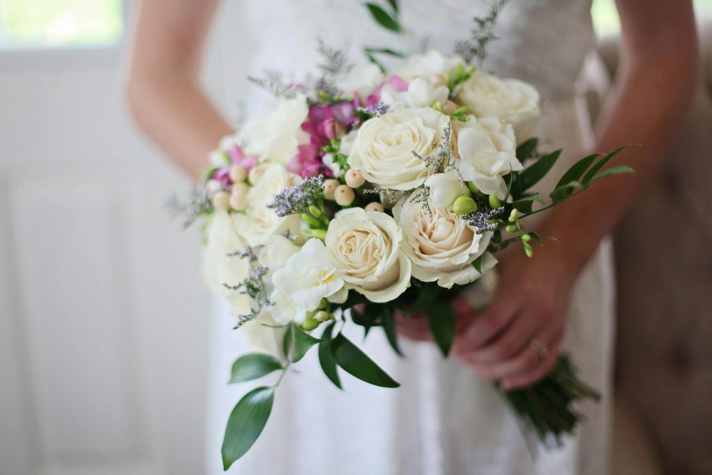 A beautiful bridal bouquet featuring white and pink roses, perfect for a wedding ceremony.
